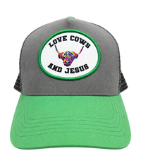 Gray and green cap with a colorful cow design and text on a transparent background